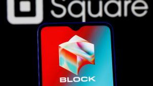 The Block (SQ) logo is shown on a phone screen, while the company's old name and logo, Square, are visible on the back of the phone.